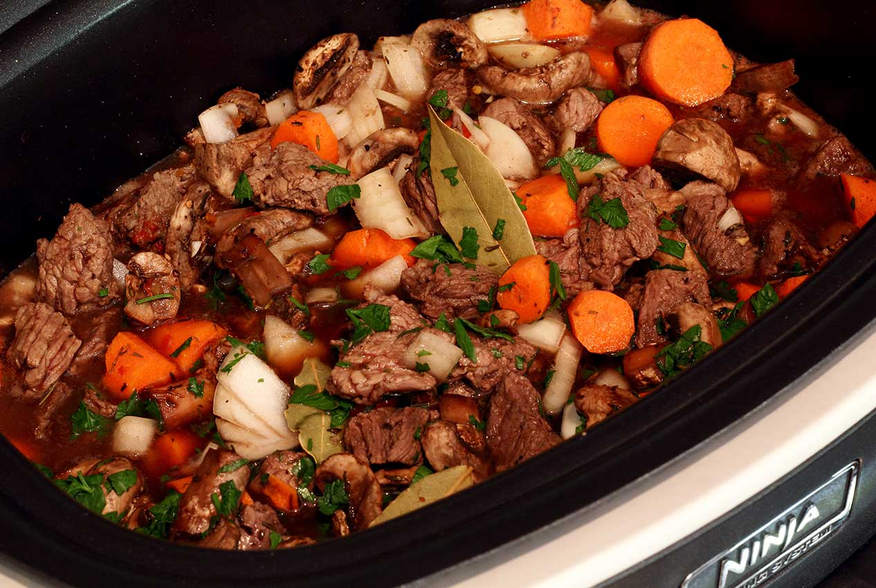 Paleo Newbie slow cooker with beef stew ingredients inside.
