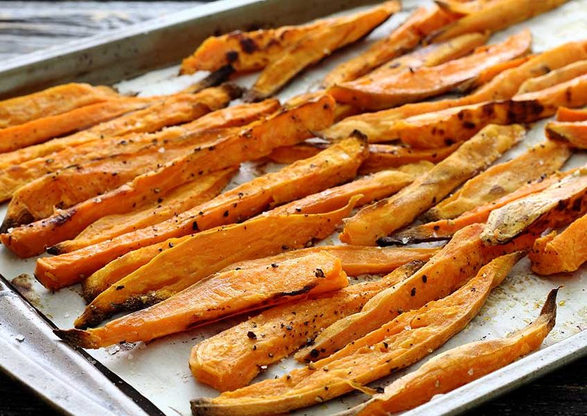 Simple paleo recipe for beef and bacon meatballs served on sweet potato fries